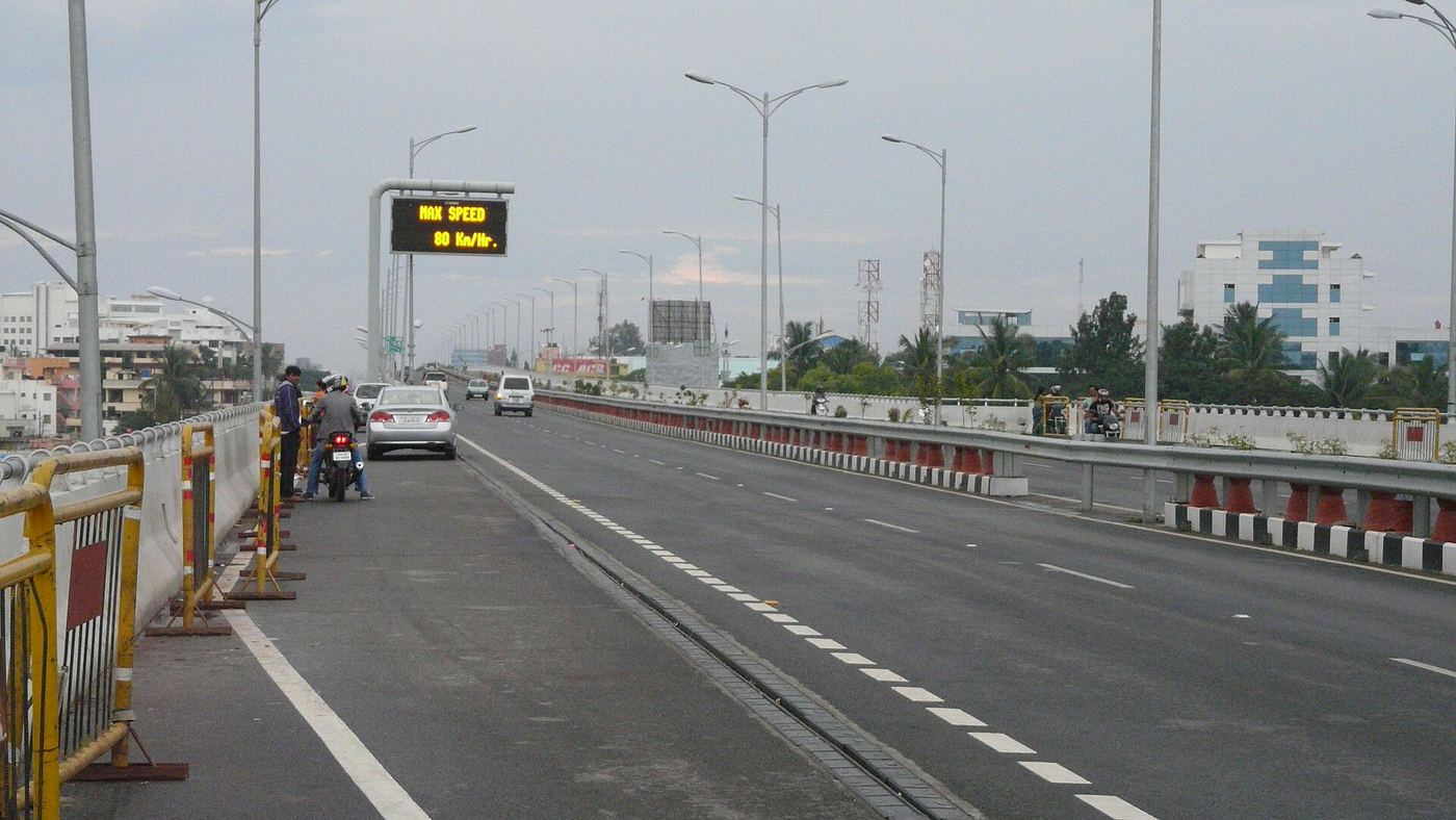 The elevated highway by day, lamp posts marching toward Electronic City